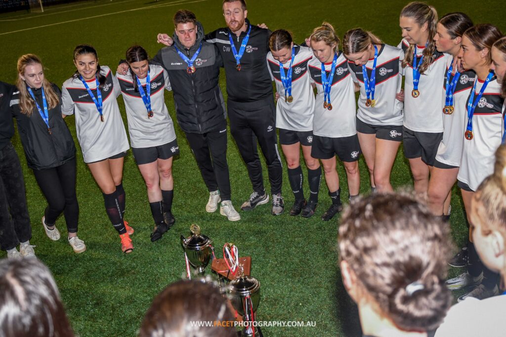 Chris Wood and the rest of the Seaforth Women's Premier League team huddle after winning the 2022 MWFA Grand Final. Photo credit: Jeremy Denham